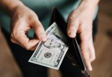 unrecognizable man holding wallet with money