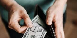 unrecognizable man holding wallet with money