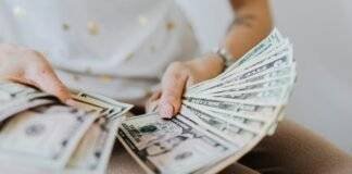 person holding fan of us dollar bills