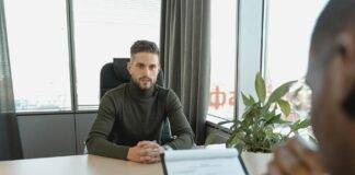 man in black long sleeve shirt sitting on chair