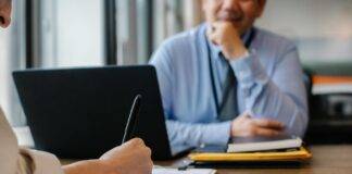 woman filling job application form in office with boss