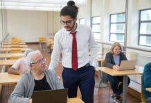 man conducting classes for elderly people learning to use computers