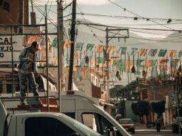 man on scaffolding near truck near street
