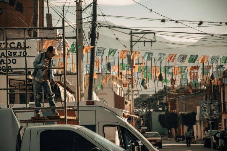 man on scaffolding near truck near street