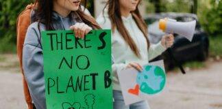woman holding a green placard