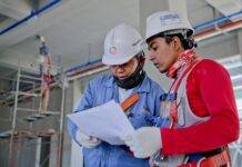 two man holding white paper