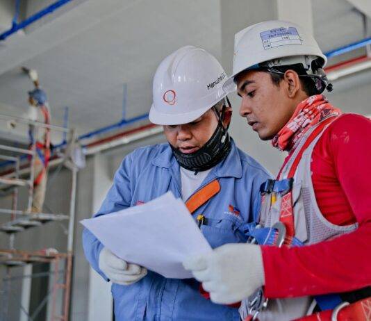 two man holding white paper