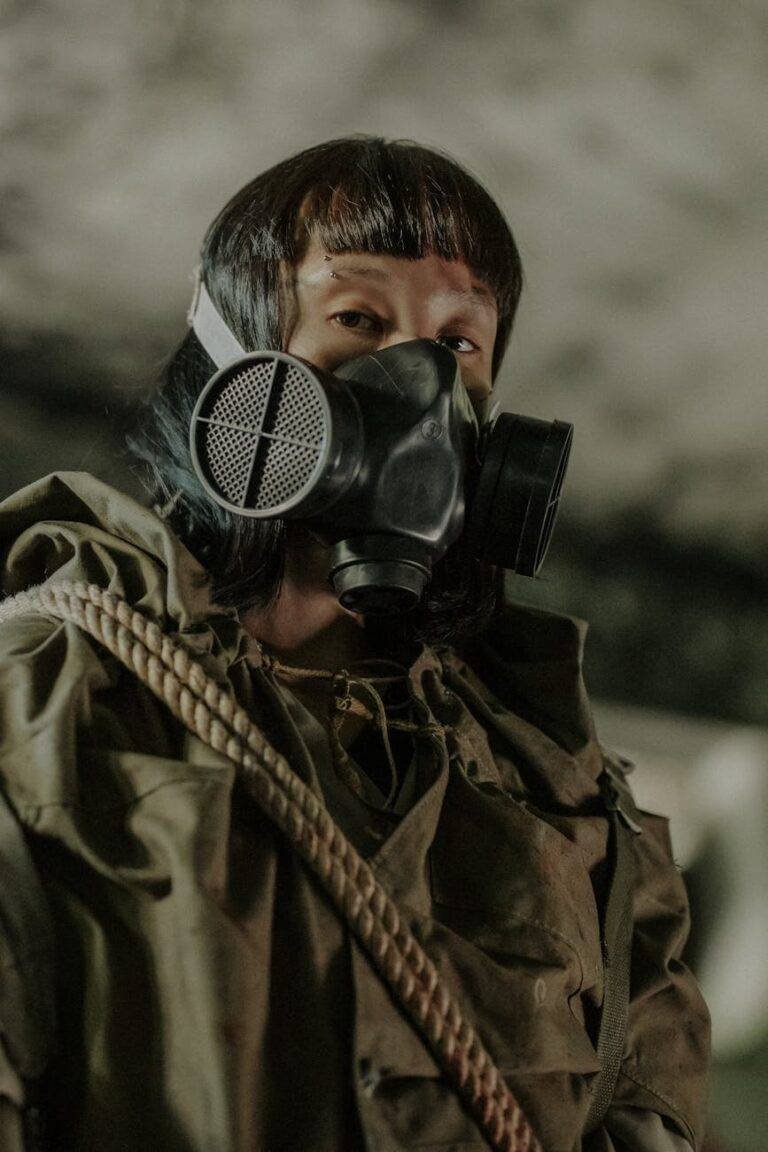 person wearing black gas mask and brown jacket