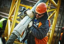 man carrying gray pipe