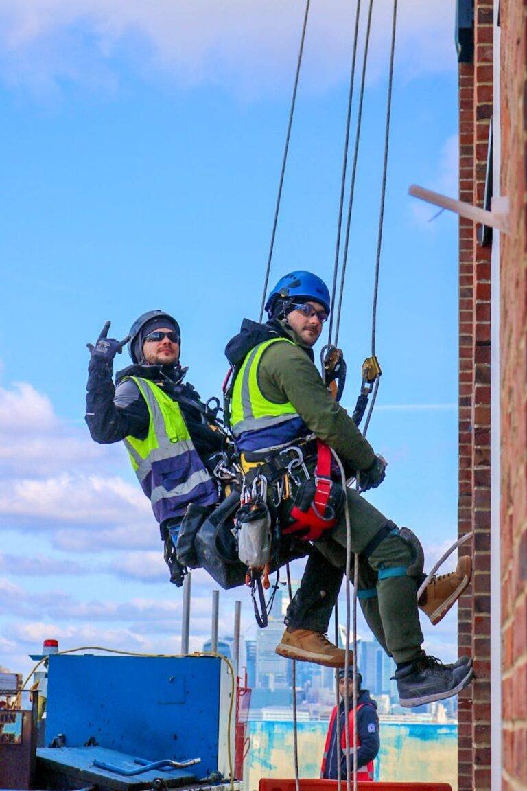 workers in climbing equipment on the building wall