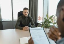 man in black long sleeve shirt sitting on chair