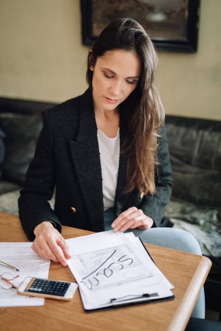 woman in black blazer sitting at the desk with documents