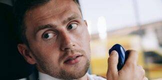 close up of a man holding a two way radio