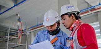 two man holding white paper