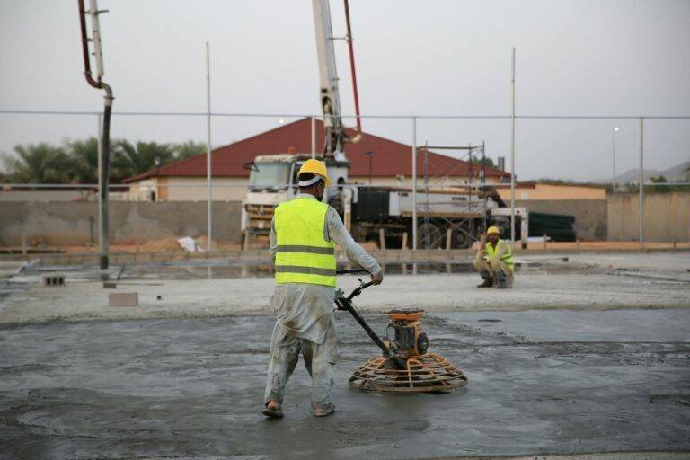 construction workers operating concrete finisher
