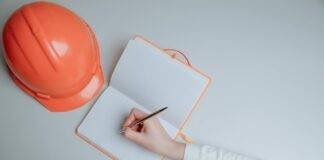 a person writing on white notebook